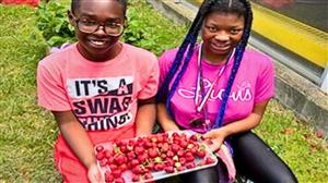  Two students holding their planting project 